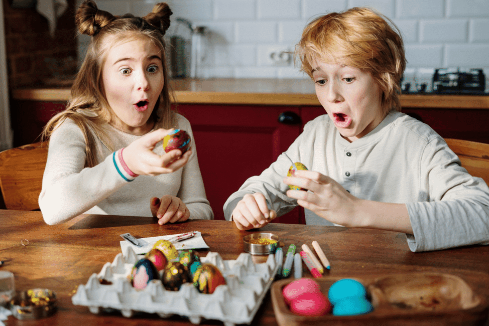 Brother and sister coloring eggs on Easter