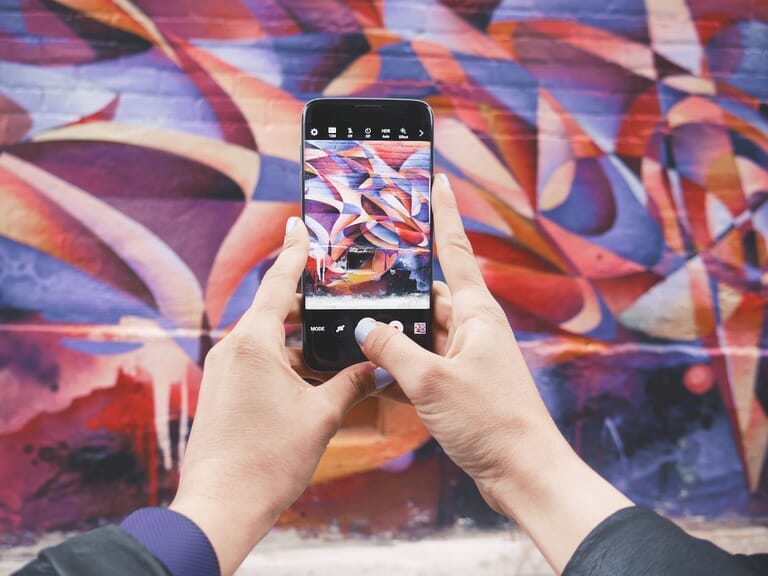 Smartphone being used to photograph a wall mural