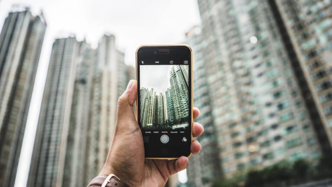 Photographer metering a building with a smartphone