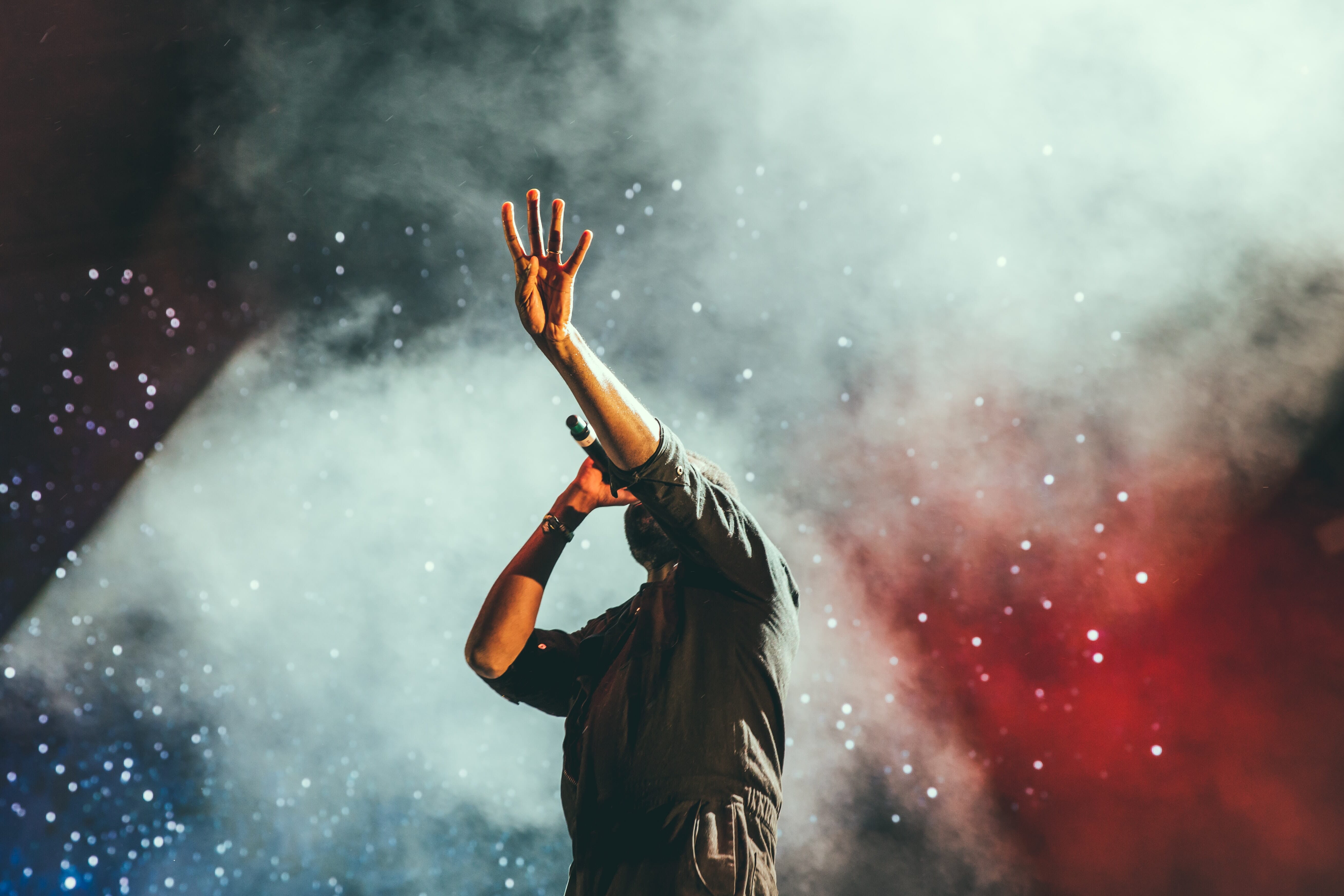 a man singing at a concert with smoke