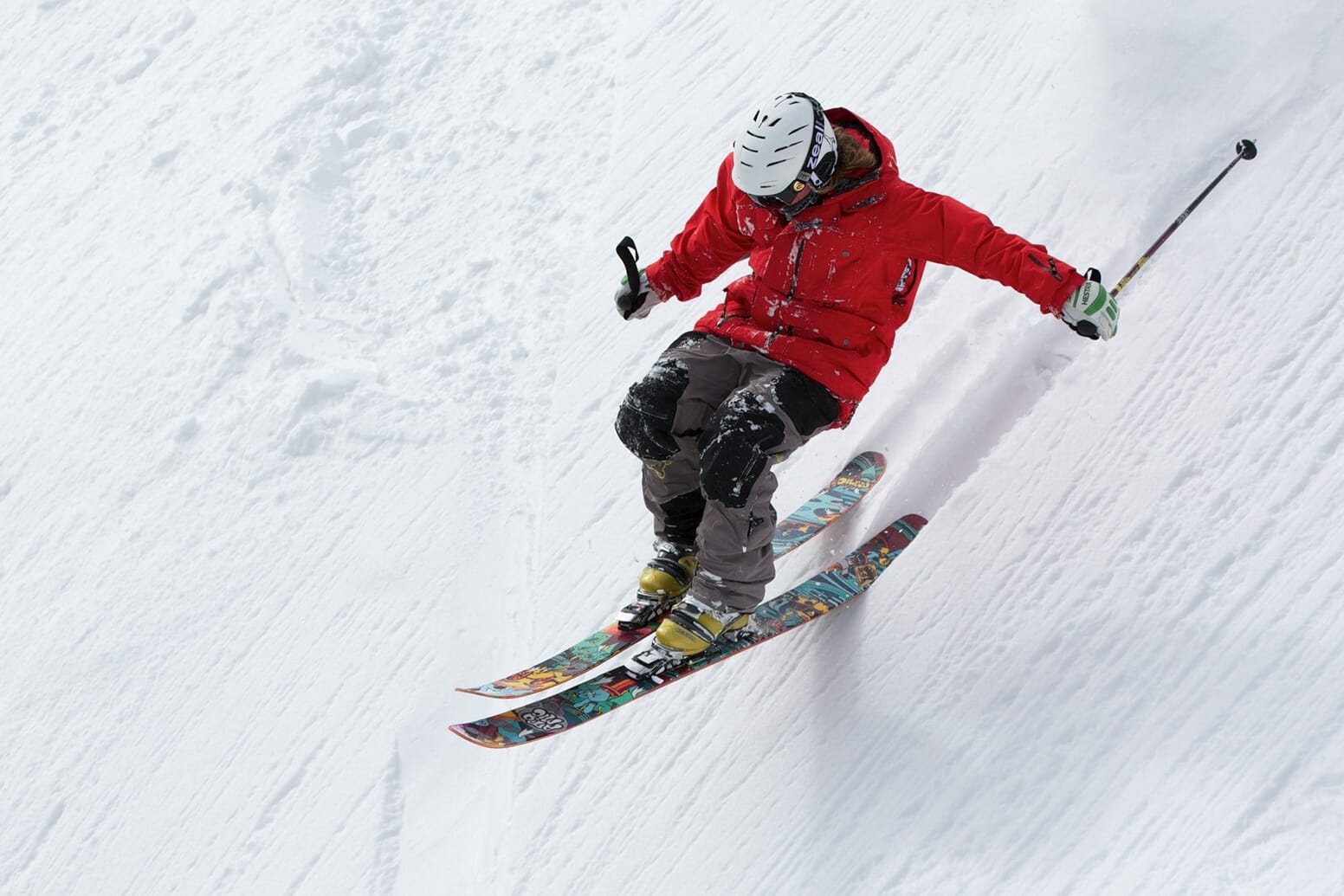 Man performing a trick while skiing down a slope