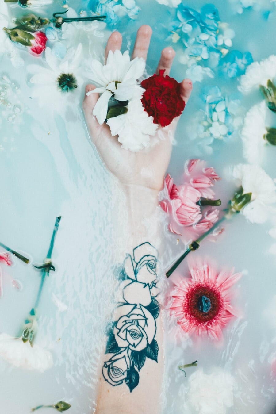 Photograph with an arm leading the eye toward flowers