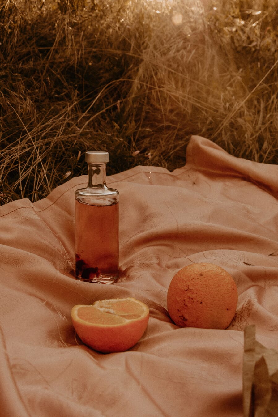 Photograph with the edge of a blanket leading toward a bottle