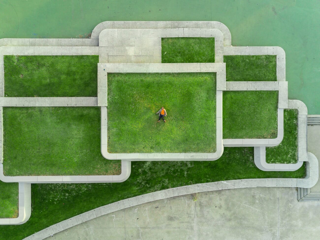 Bird's eye view of a person on a geometric green terrace, demonstrating a high camera angle
