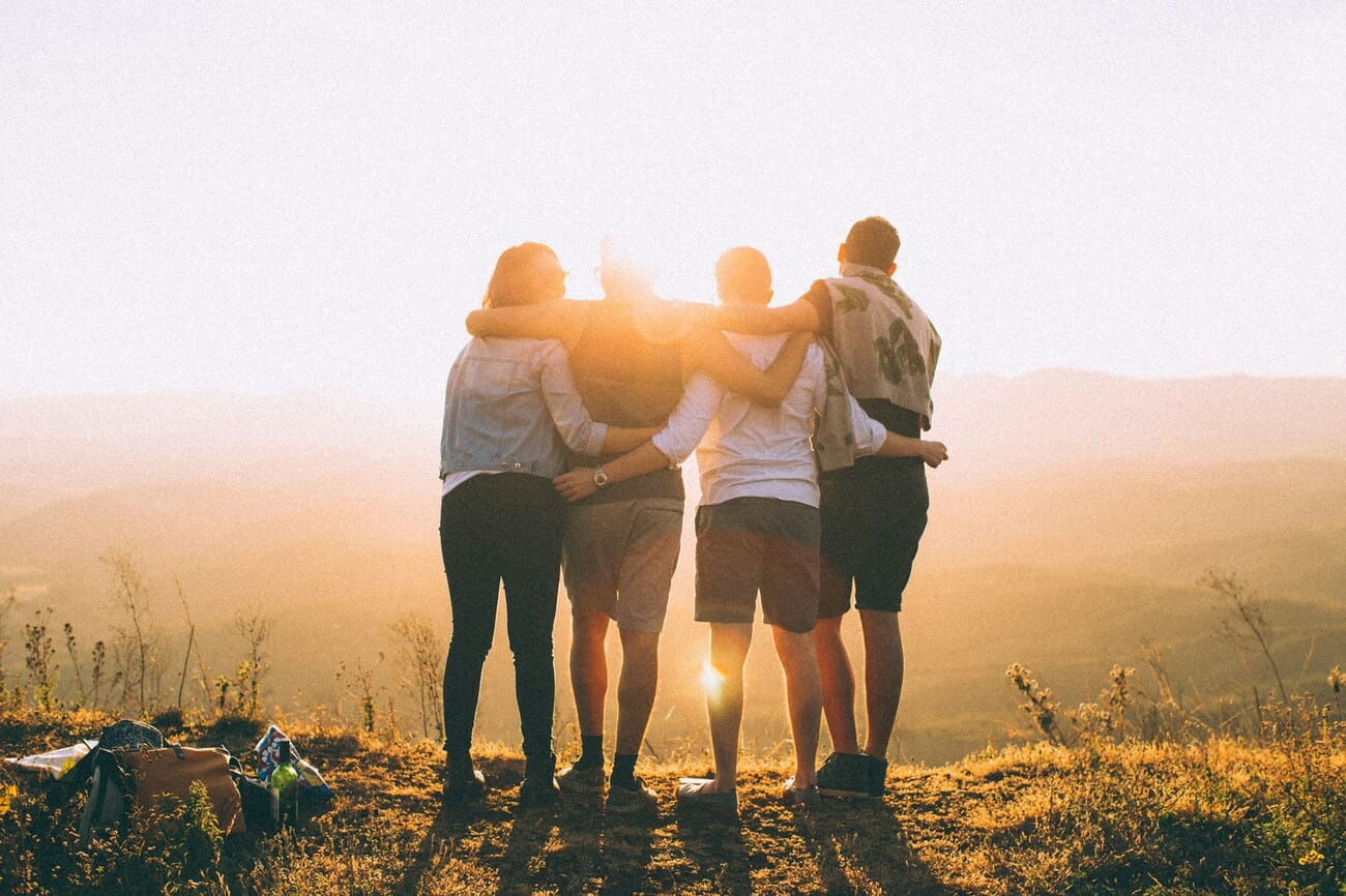 Group of friends at golden hour bathed in warm orange and gold tones, an example of warm colors in photography