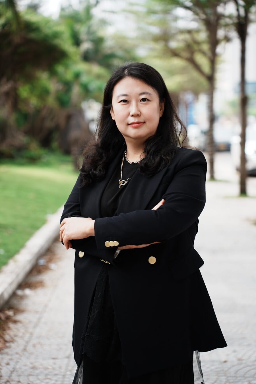 Woman in a blazer with arms casually crossed creating confident body language