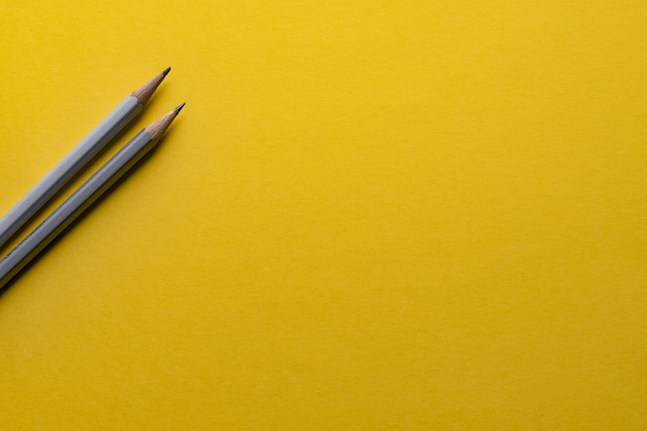 Minimalist photo with negative space - pencils on vibrant yellow background