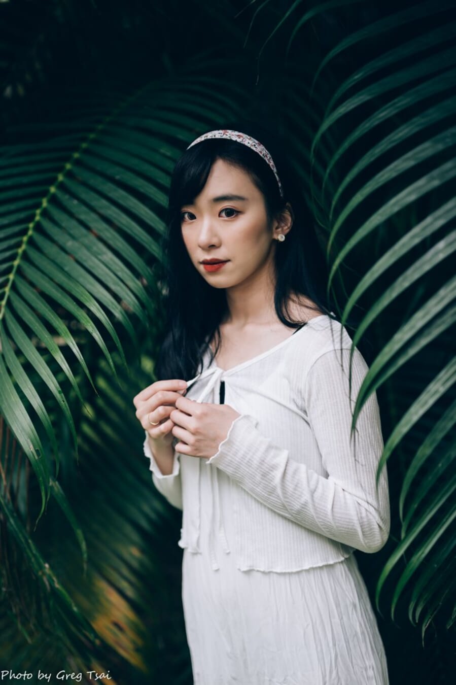 Natural-looking portrait of a woman among green foliage, shot at 50mm