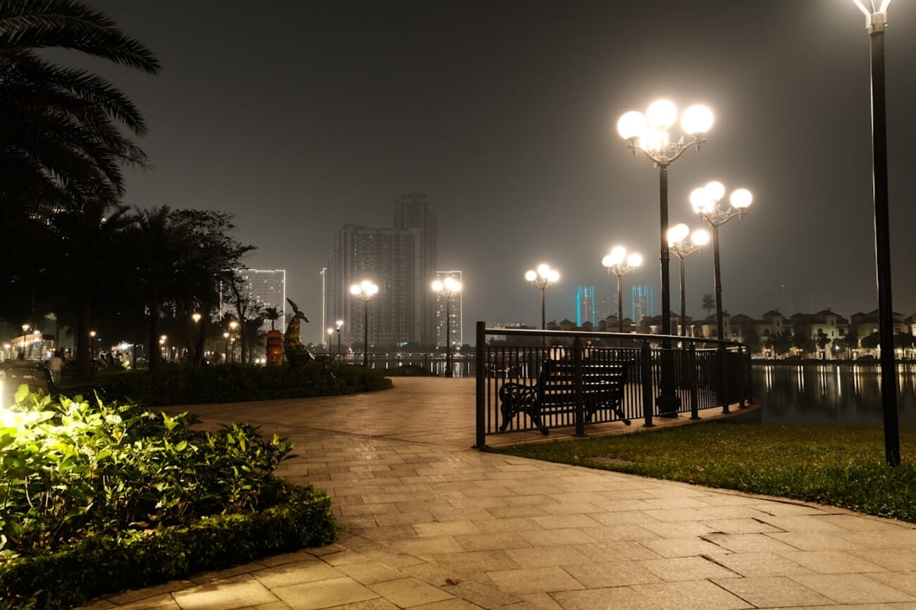 Waterfront promenade at night with warm lamp light and reflections, shot on Fujifilm X-T30 II
