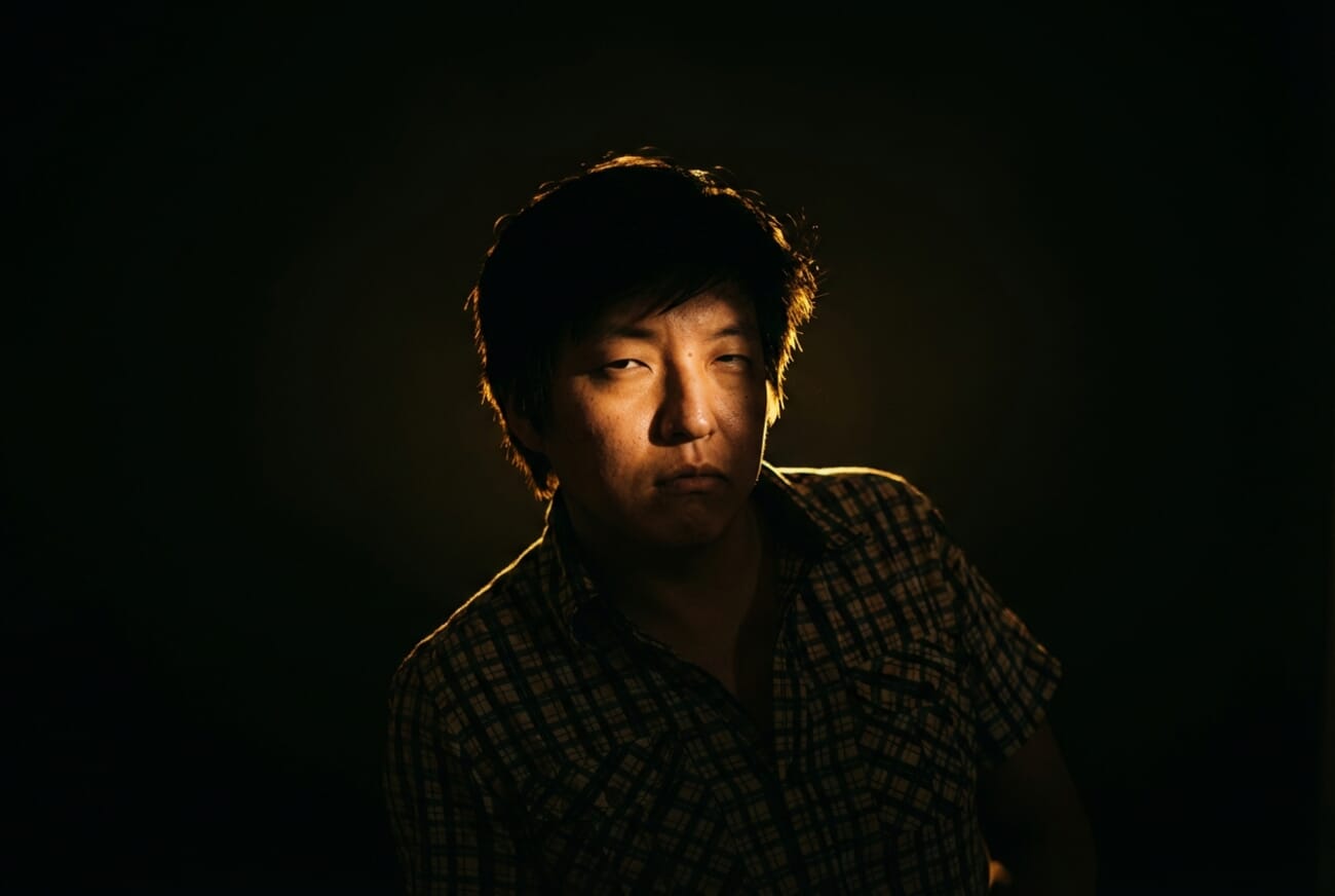 The same portrait after Gemini AI relighting with dramatic Rembrandt-style shadows and warm rim light