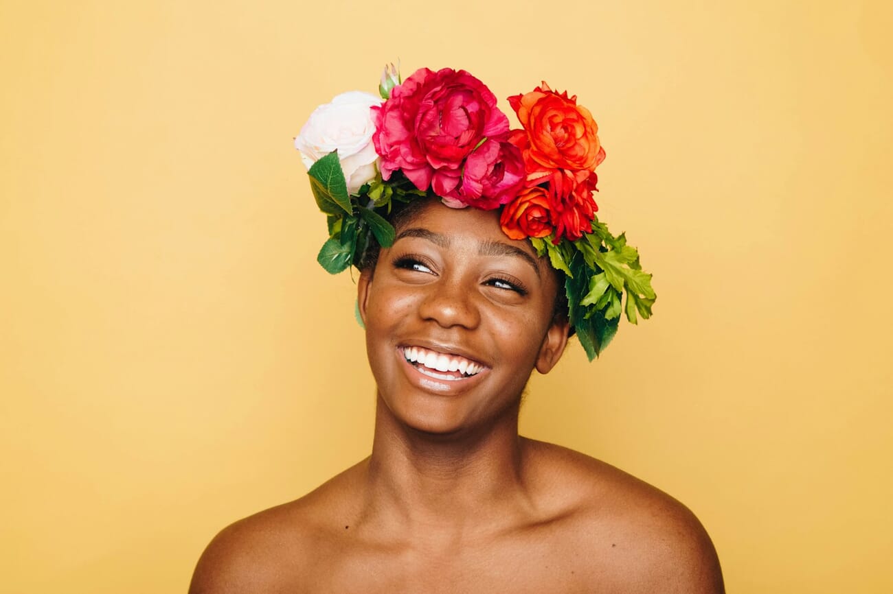 Bright airy portrait of a woman with a floral crown photographed with high key lighting technique