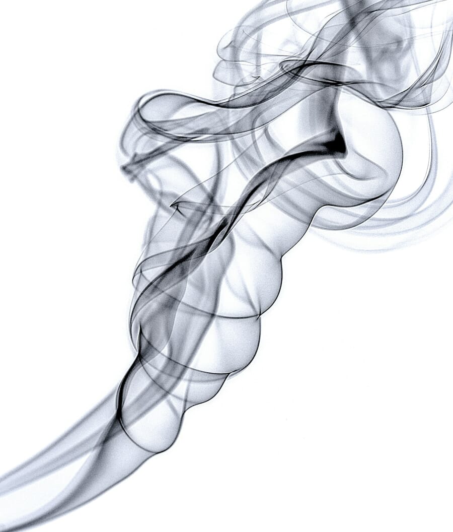 Abstract photograph of incense smoke rising and swirling against a dark background