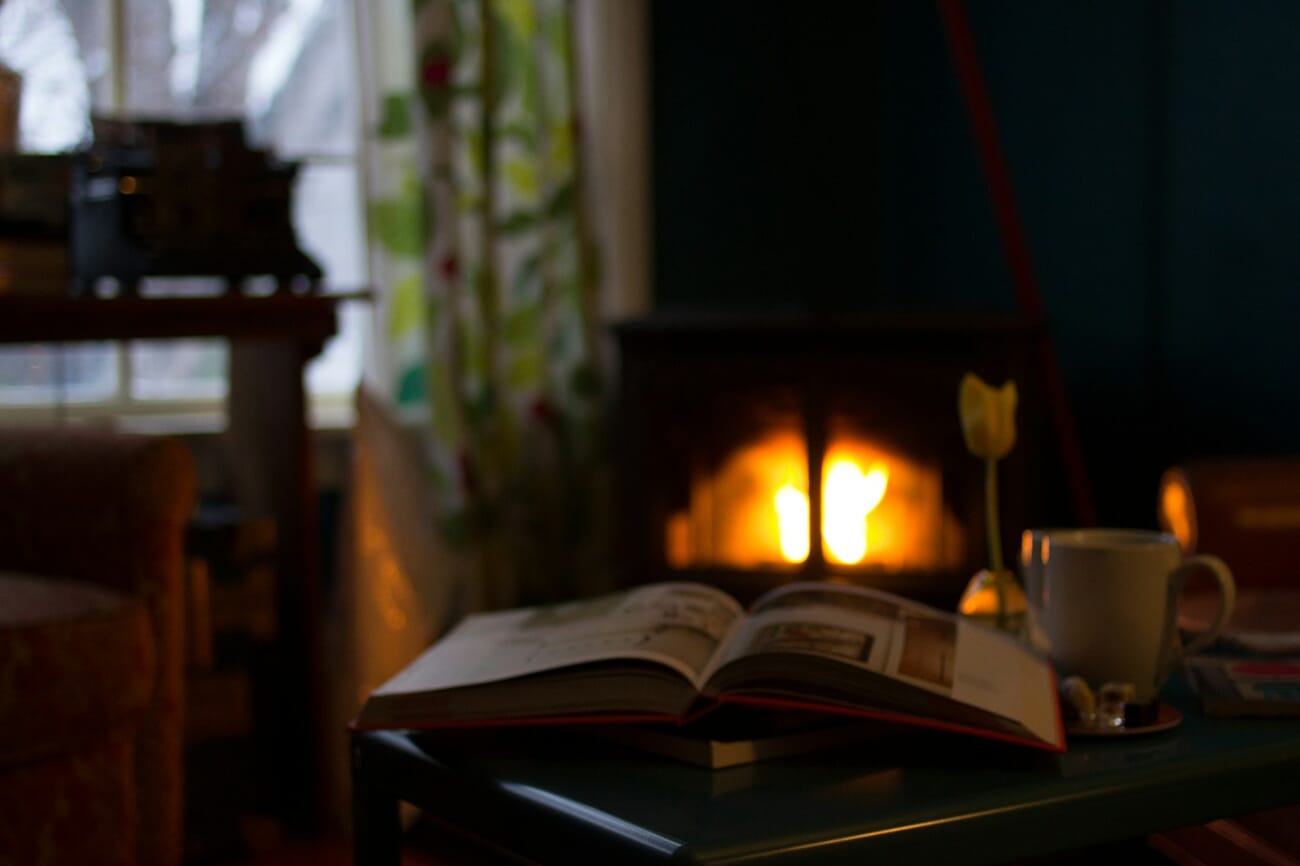 Point-of-view indoor photograph of feet in wool socks with a warm blanket