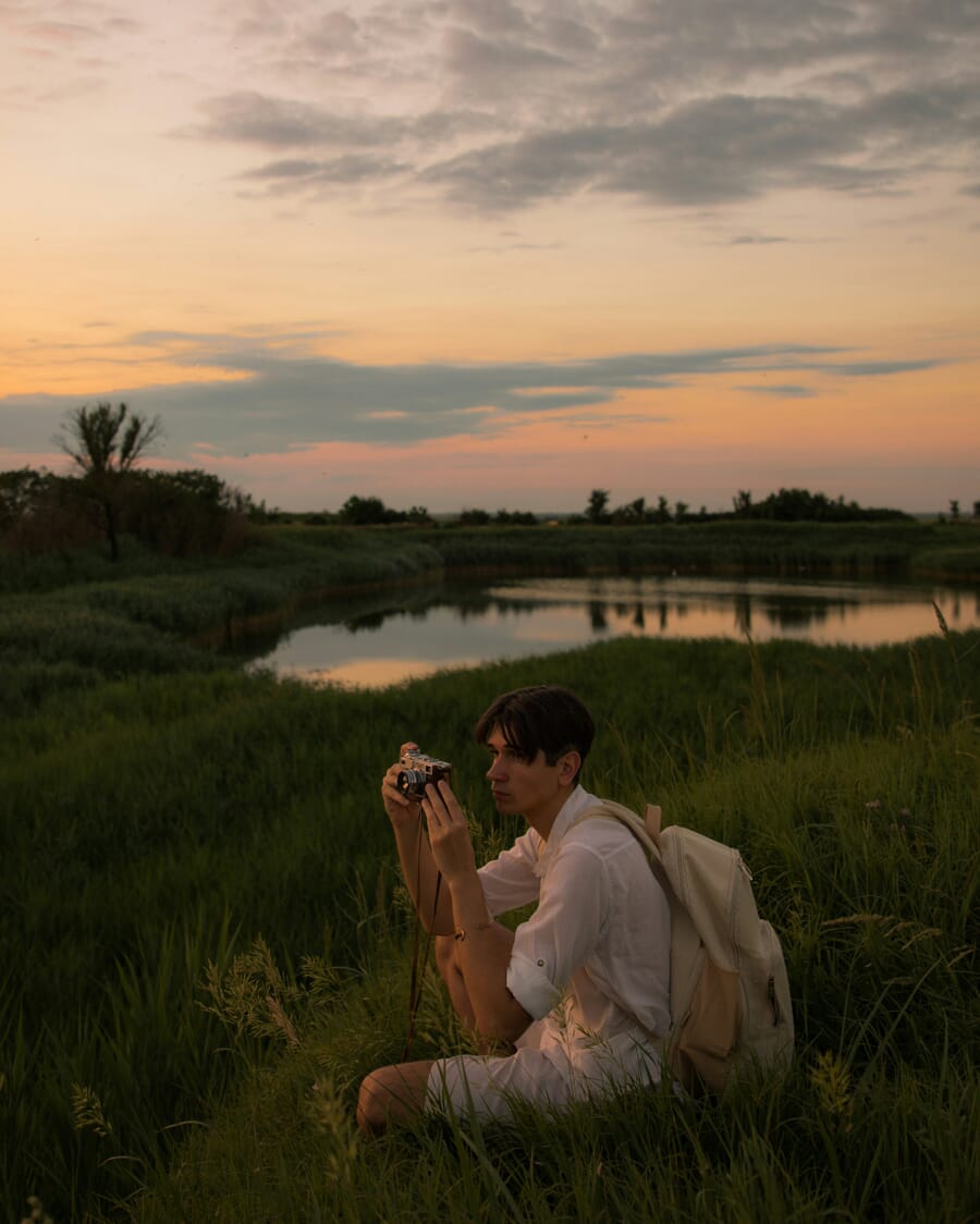 A young man in a crouching position, carefully taking a shot; Surrounded by gorgeous, lush nature || 📸 Photo by: Jovan Vasiljević ; 👤 Model: Jovan Vasiljević (self-portrait)