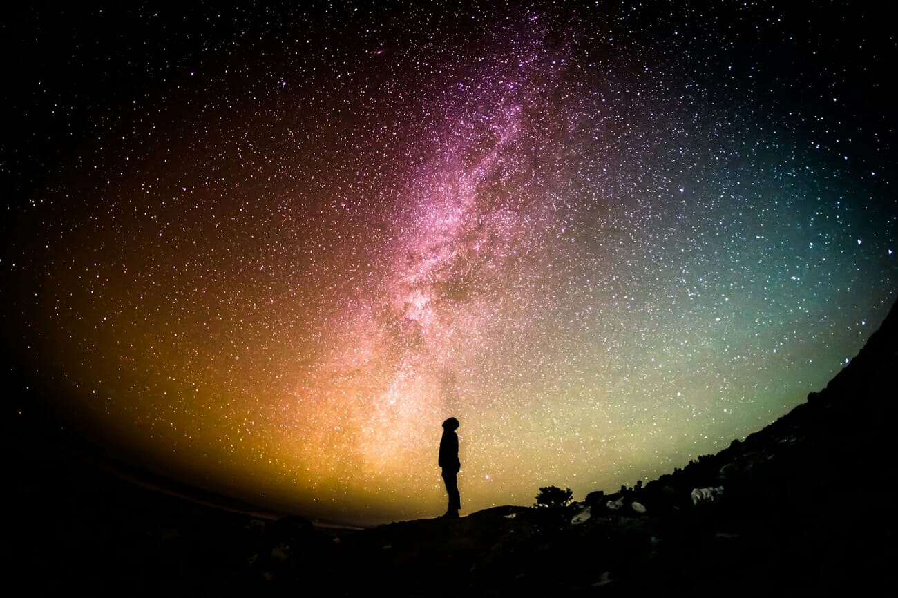 Milky Way astrophotography with person silhouetted against the night sky