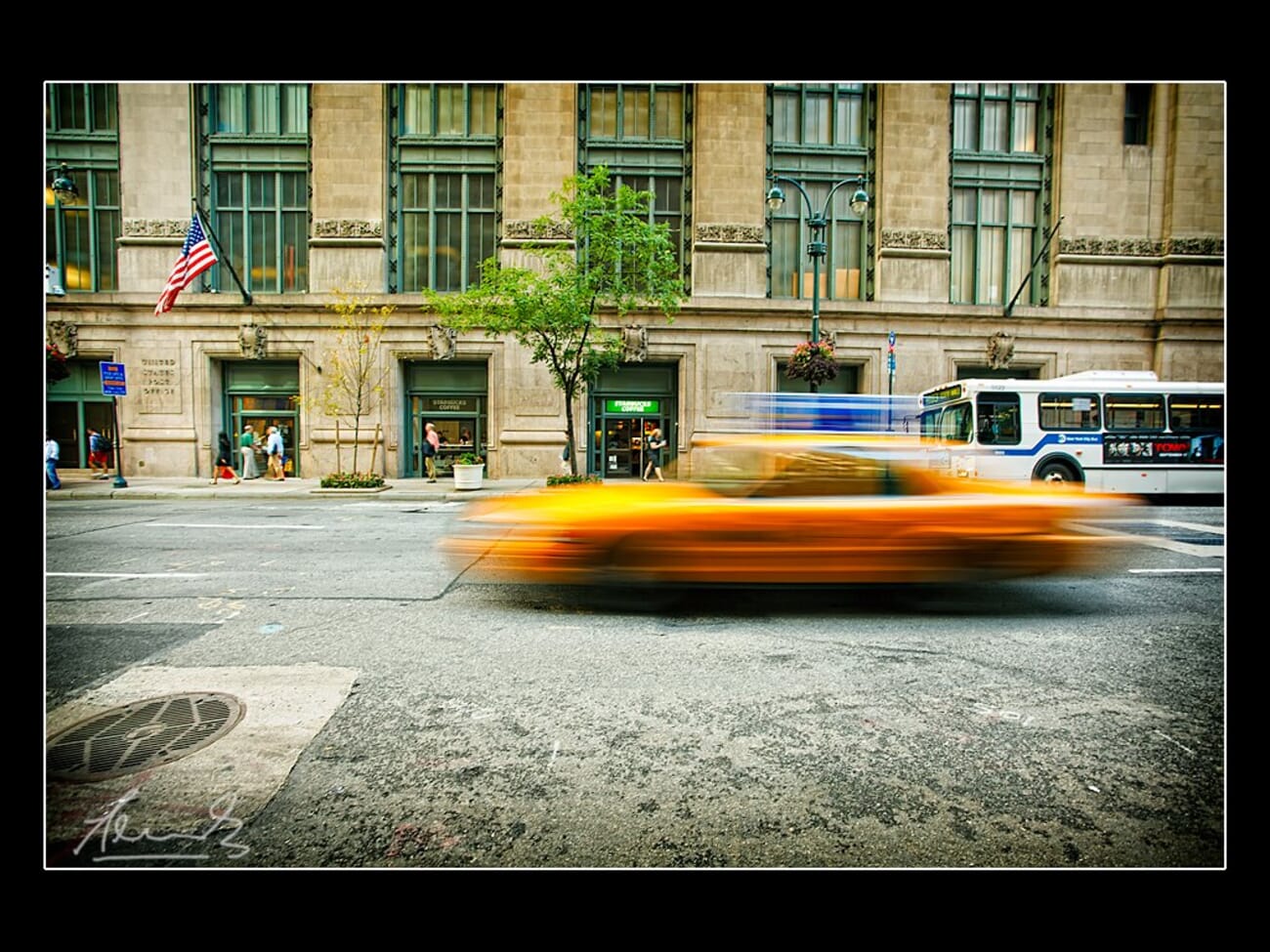 A yellow taxi streaks across a Manhattan street as motion blur while the buildings stay sharp