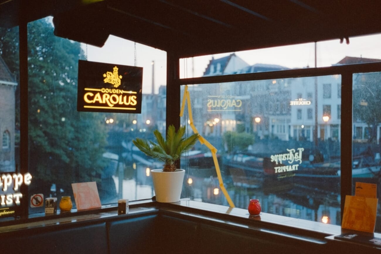 Cozy café interior with glowing sign — shot on Minolta CLE in Rotterdam