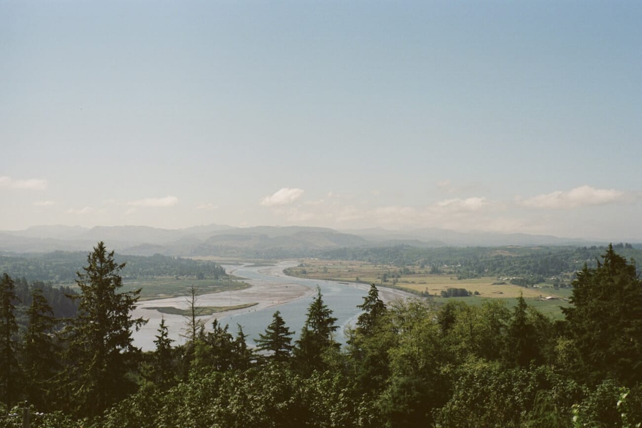 Serene riverbend through forested hills — shot on Minolta X-370