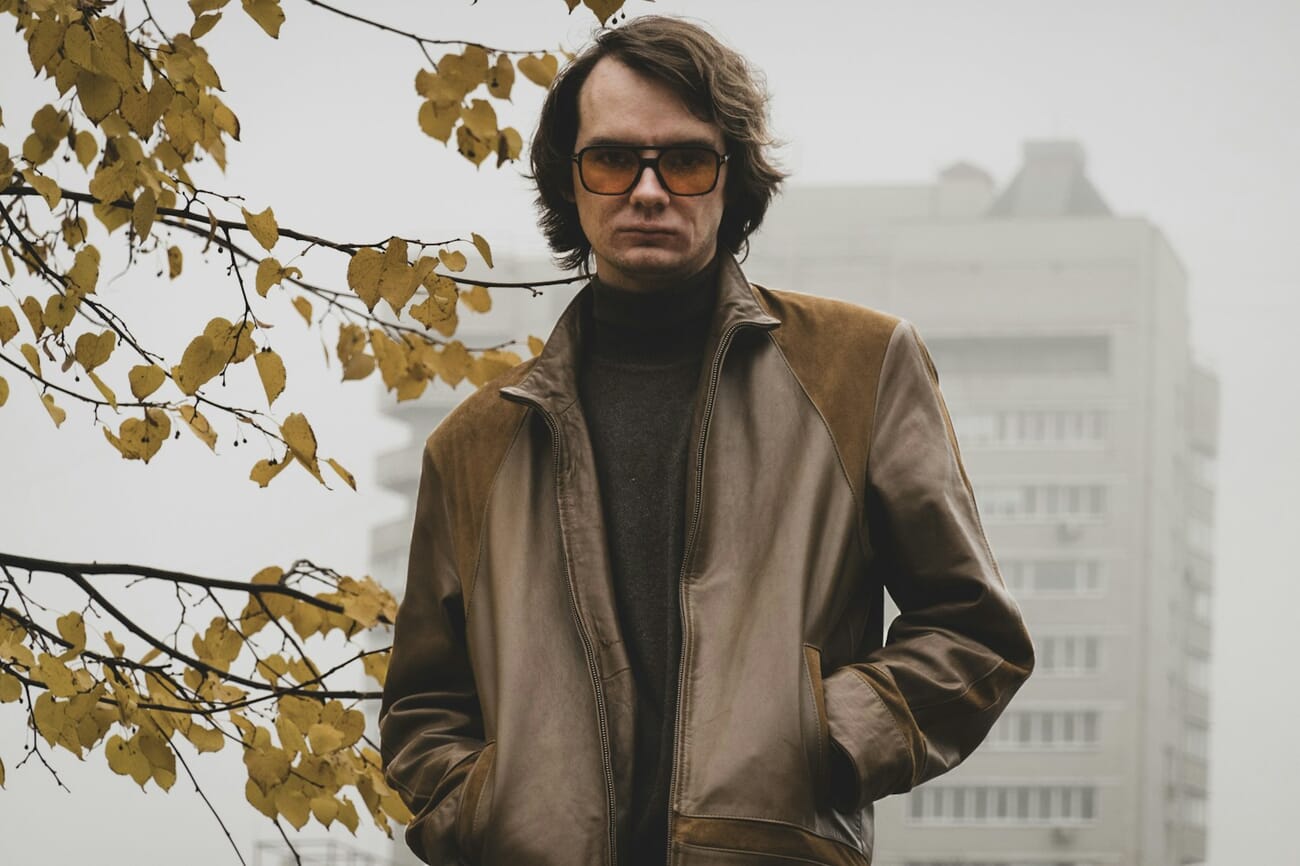 Man in brown jacket photographed on an overcast foggy day