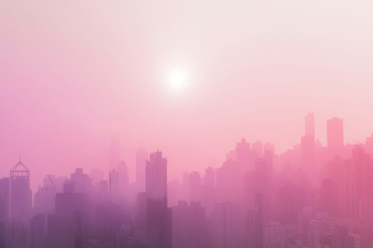 Urban street scene at sunrise with pink haze and city buildings