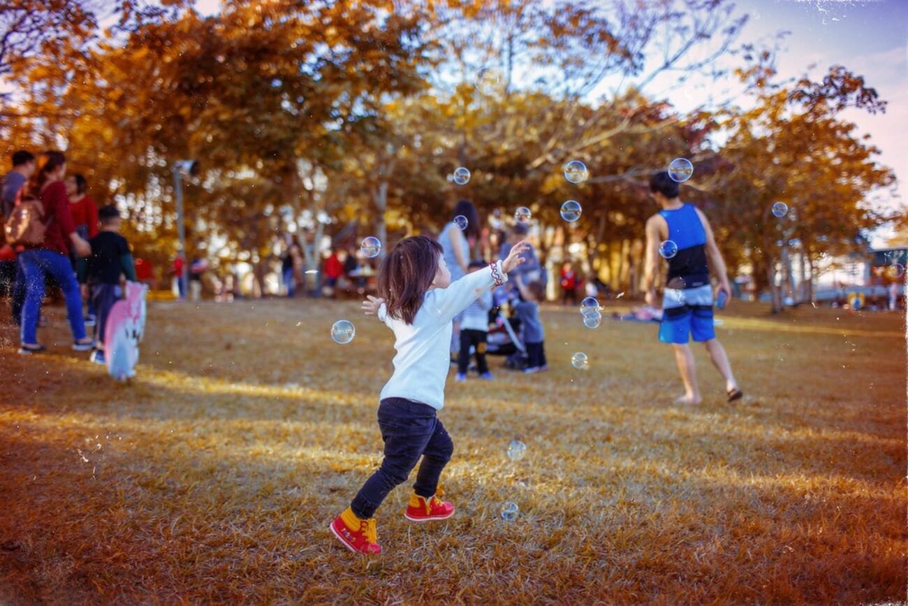 Children playing in a park among autumn foliage
