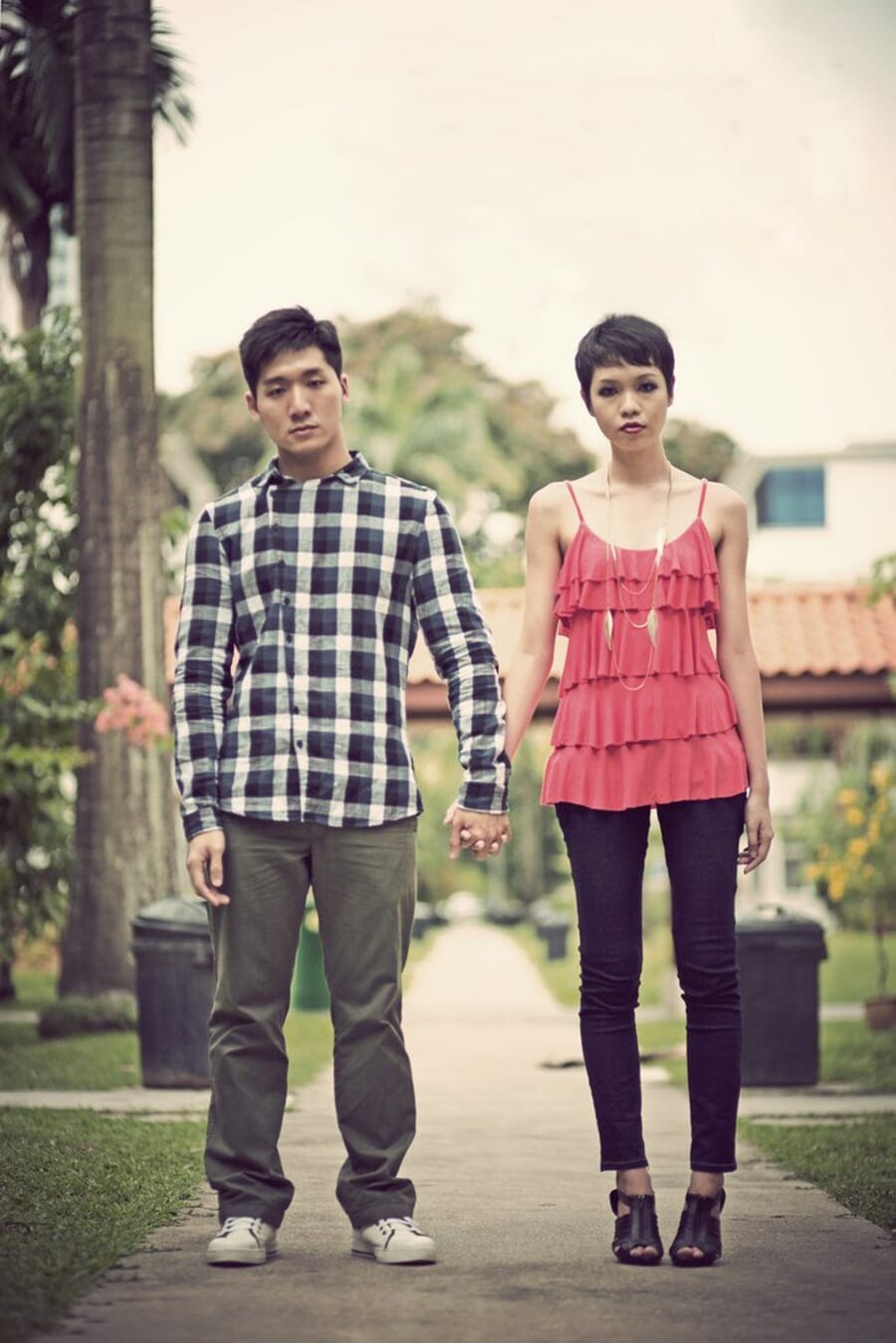 Couple holding hands while walking along a sunlit path