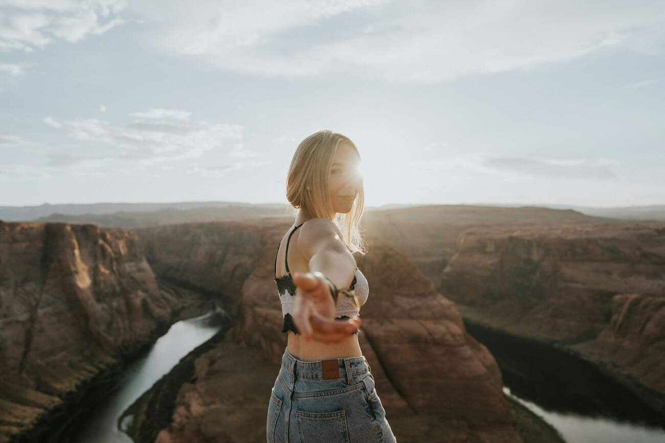 Portrait with golden rim light outlining hair and shoulders against canyon backdrop