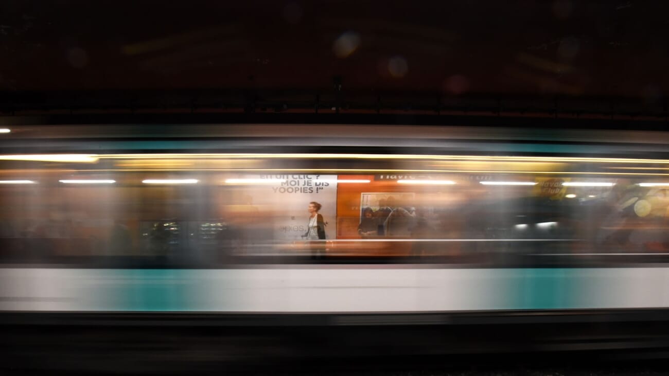 Urban motion captured with a panning technique — some blur in the foreground, the subject rendered sharply by matched shutter speed, shot at f/22.0 · 1/5 · ISO 2500