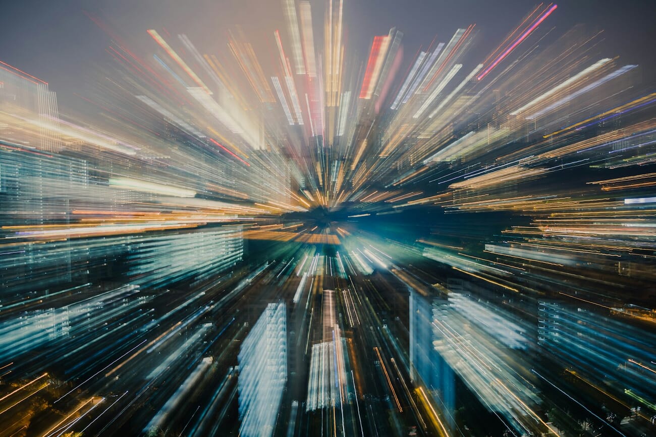 Light trails streaking across an urban scene from a long exposure, traffic blurred into ribbons of color, shot at f/4.0 · 5s · ISO 100
