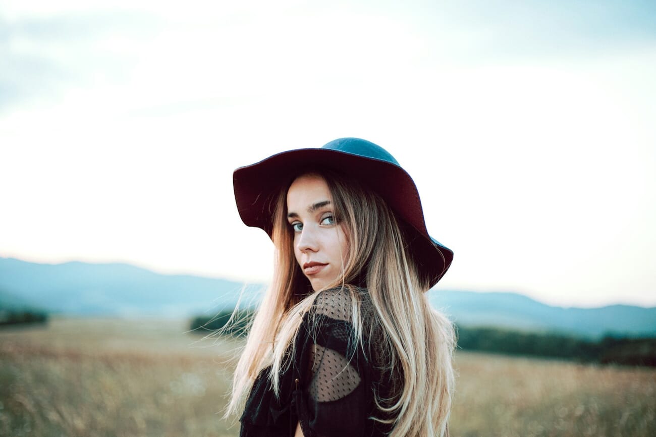 Woman with long blonde hair wearing a hat photographed in natural light with Canon 5D Mark III