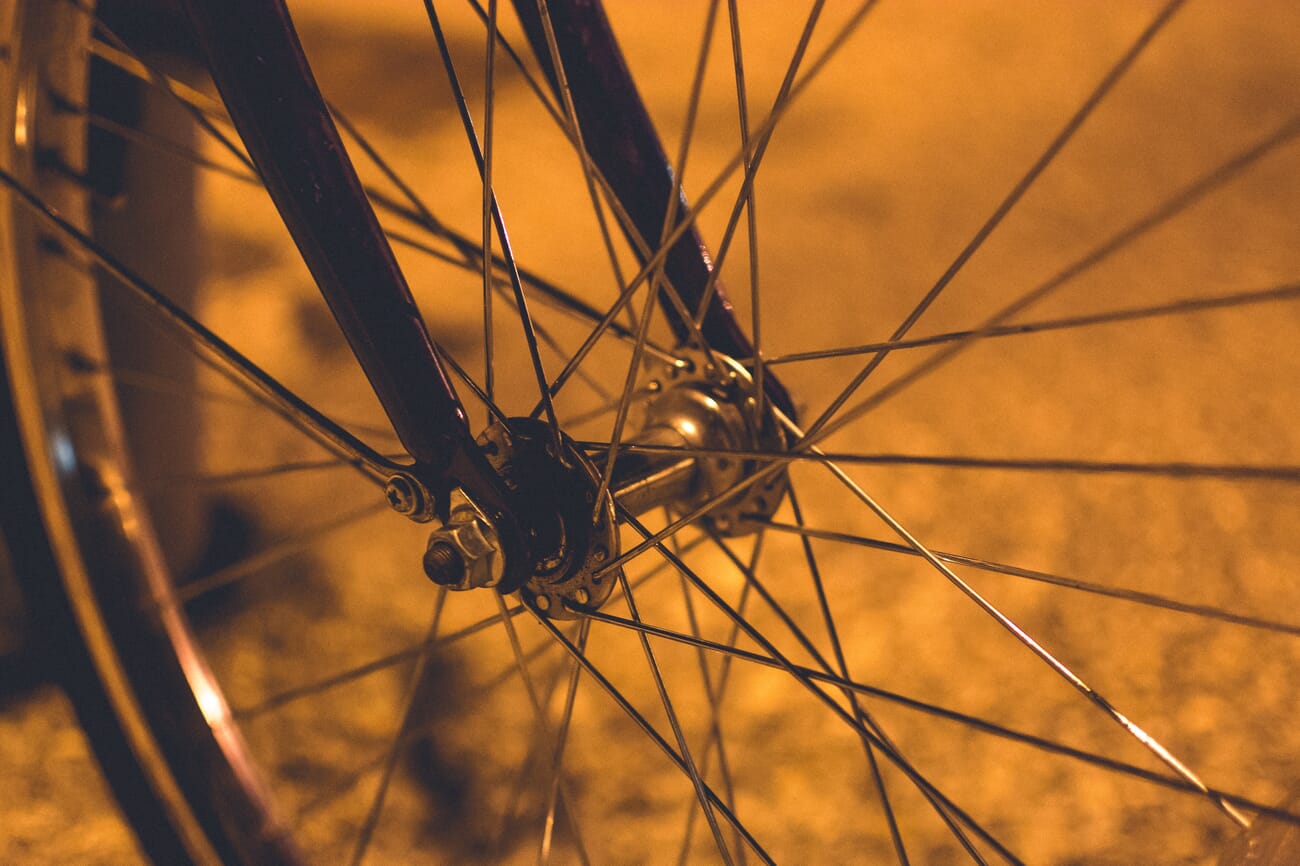 Close-up of bicycle spokes lit by warm orange light