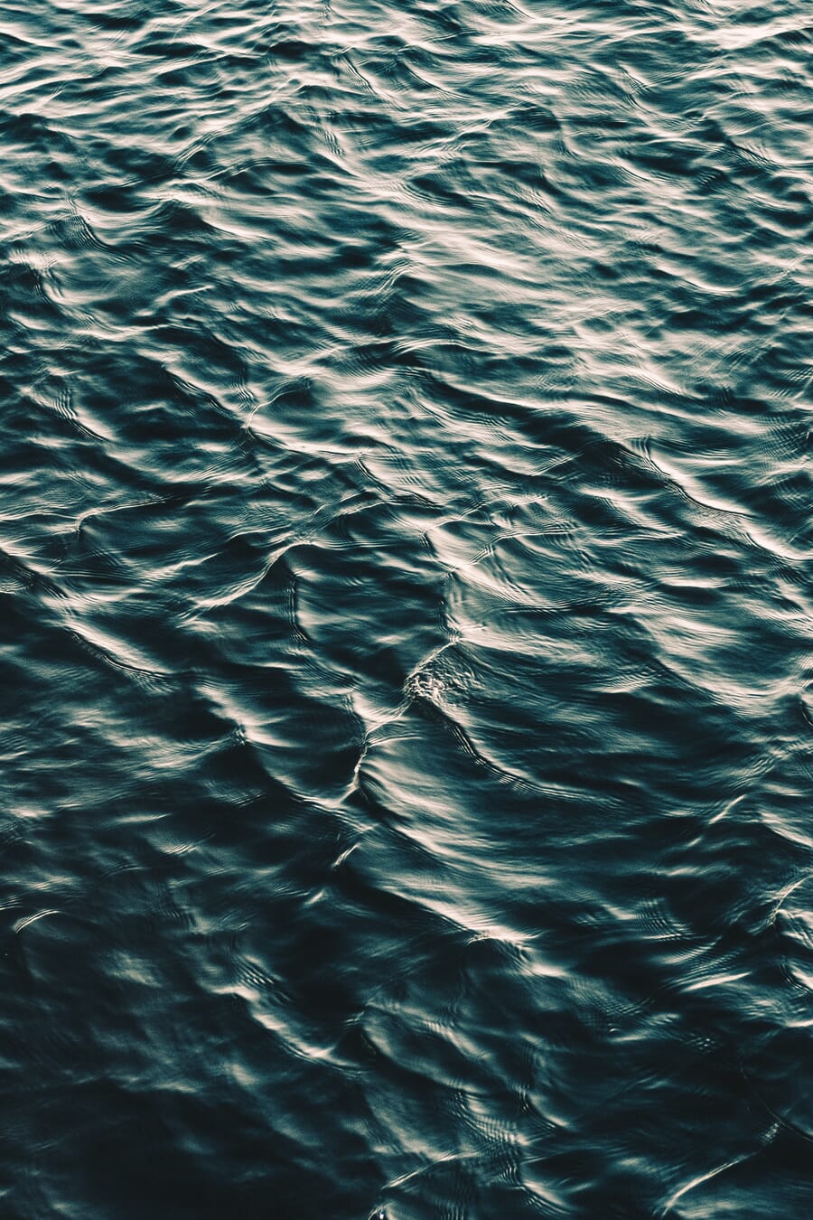 Dark blue ocean water surface with gentle ripples creating subtle texture
