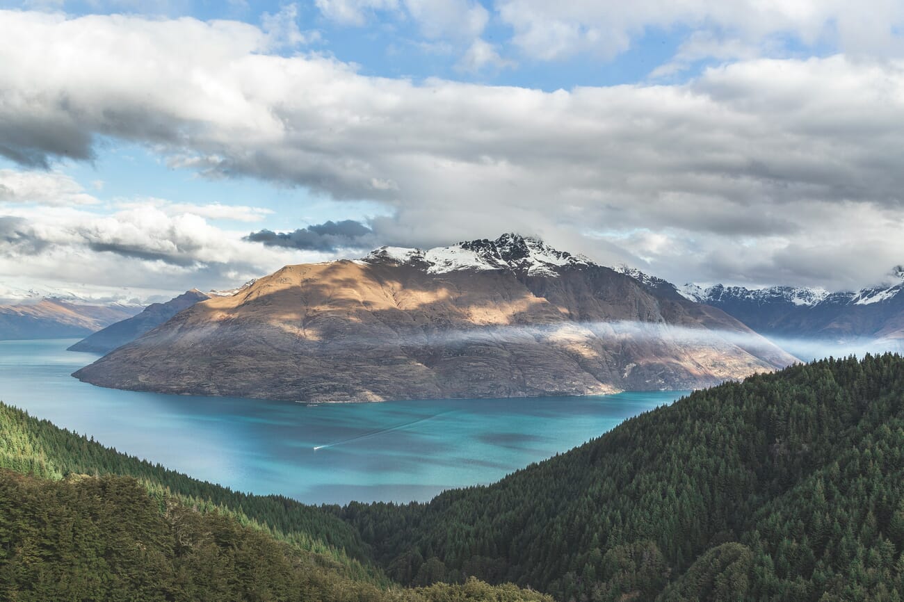 Majestic mountain reflected in a serene lake under dramatic skies telling a story of wilderness and solitude