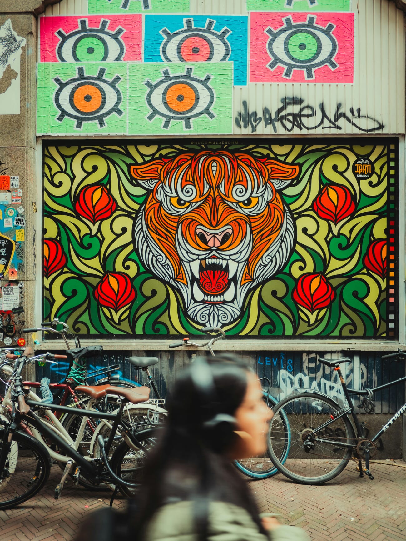 Colorful tiger street art mural with cyclist passing by
