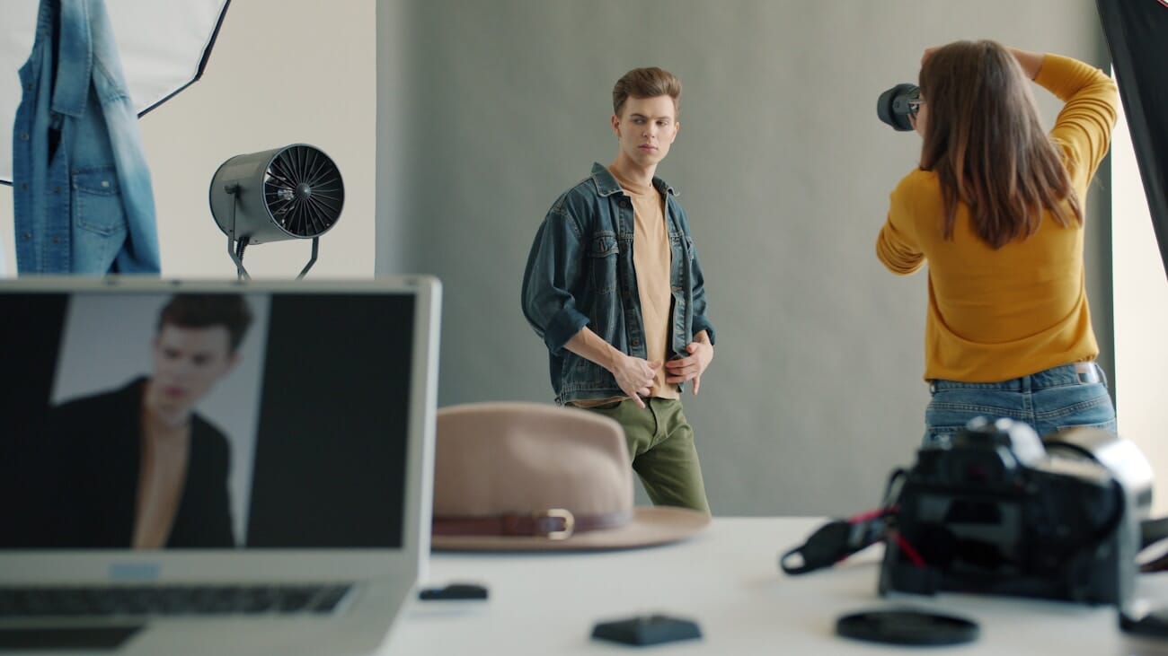 Photographer directing a male model during a studio portrait session