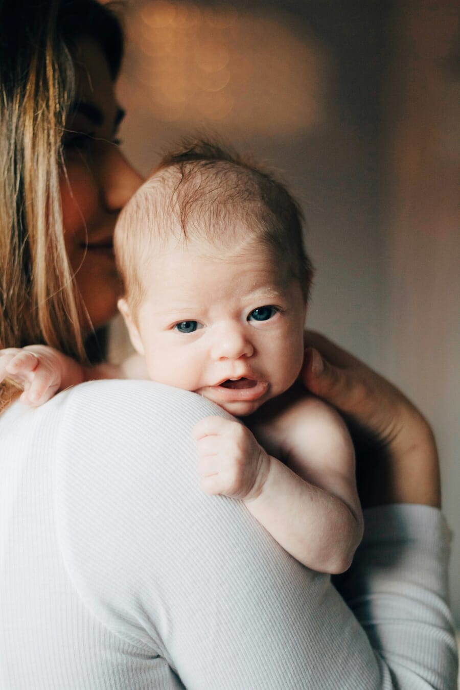 Mother and newborn baby in tender soft natural window light