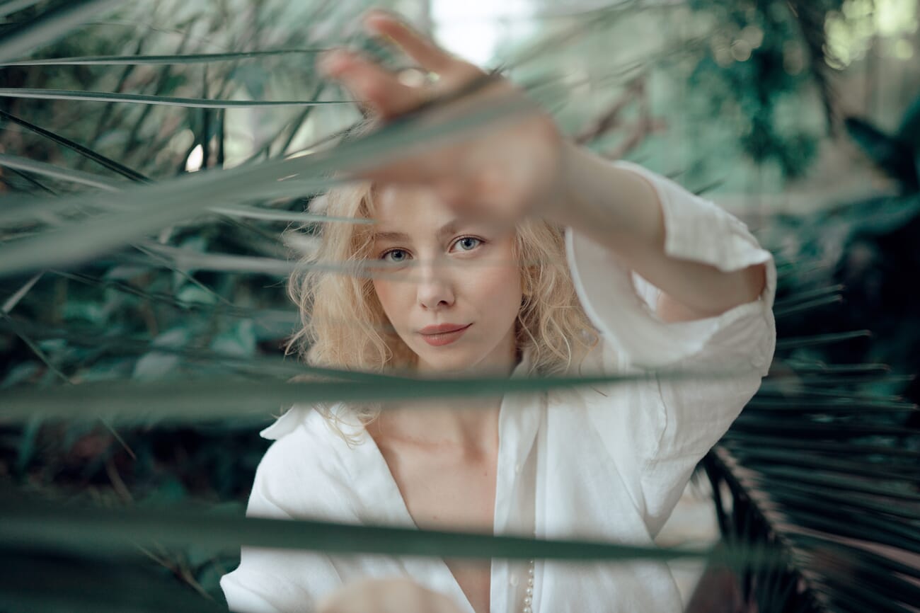Portrait photographed through leaves and greenery