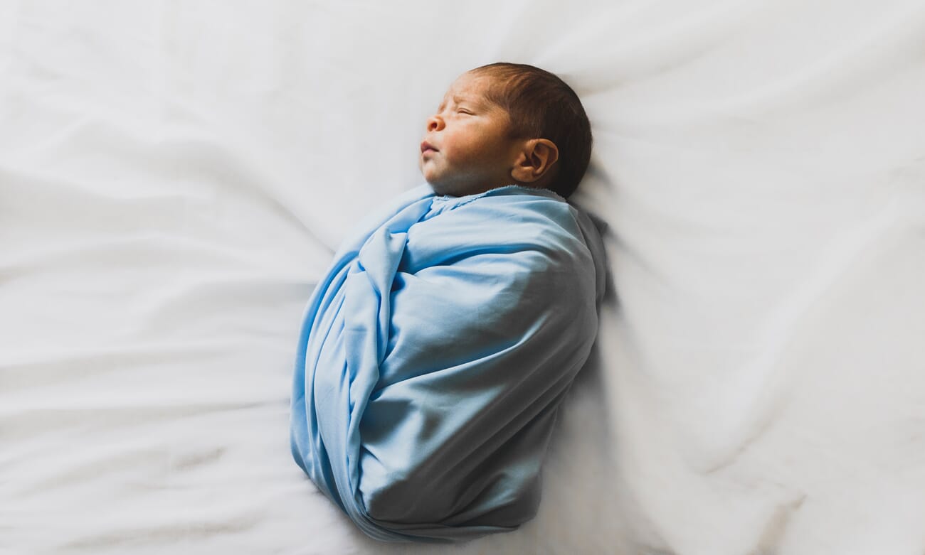 Newborn photoshoot idea at home: Swaddled on the Bed