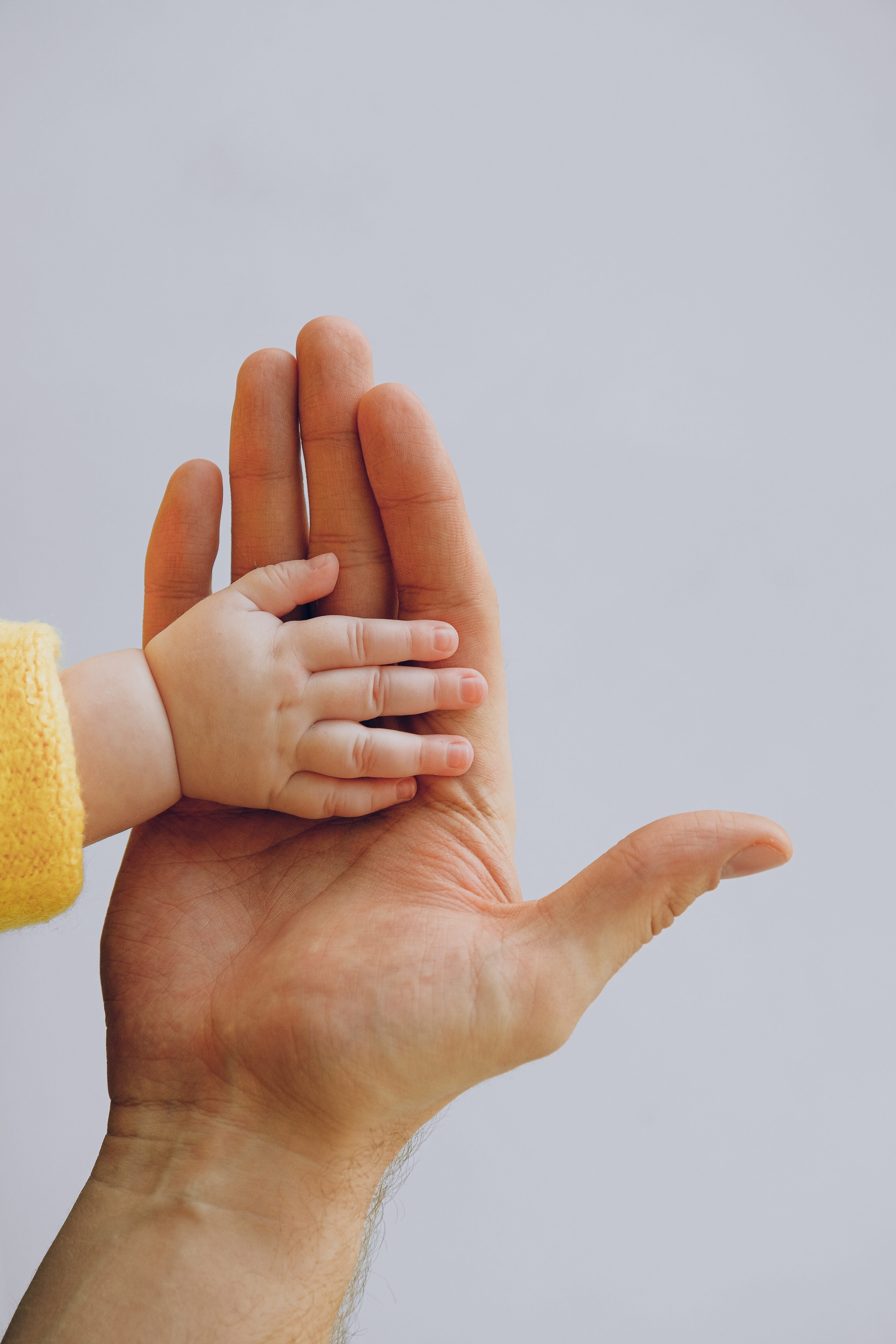 A small hand meets a big hand.