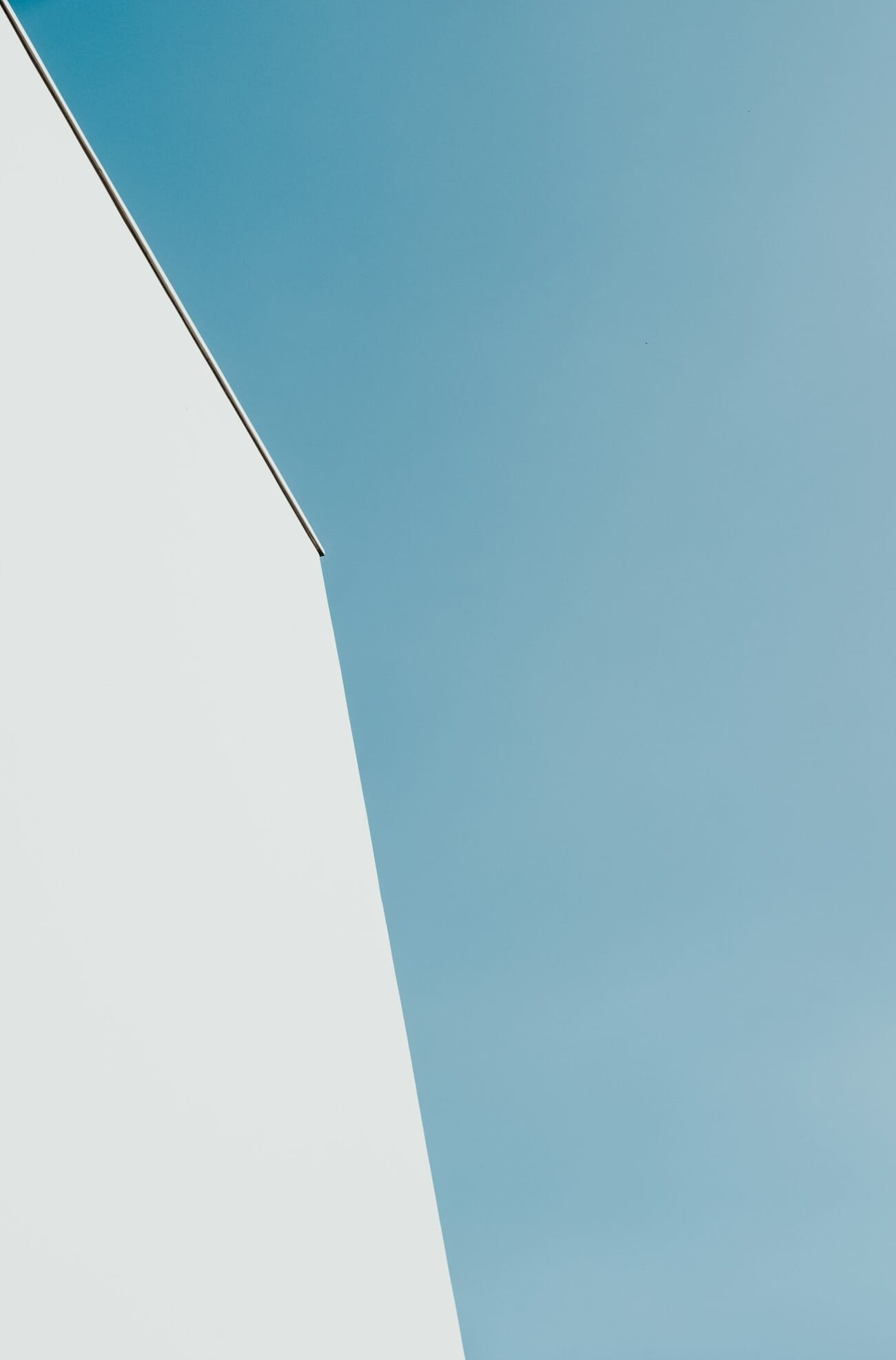 Minimalist photograph of a white architectural edge against a clear blue sky
