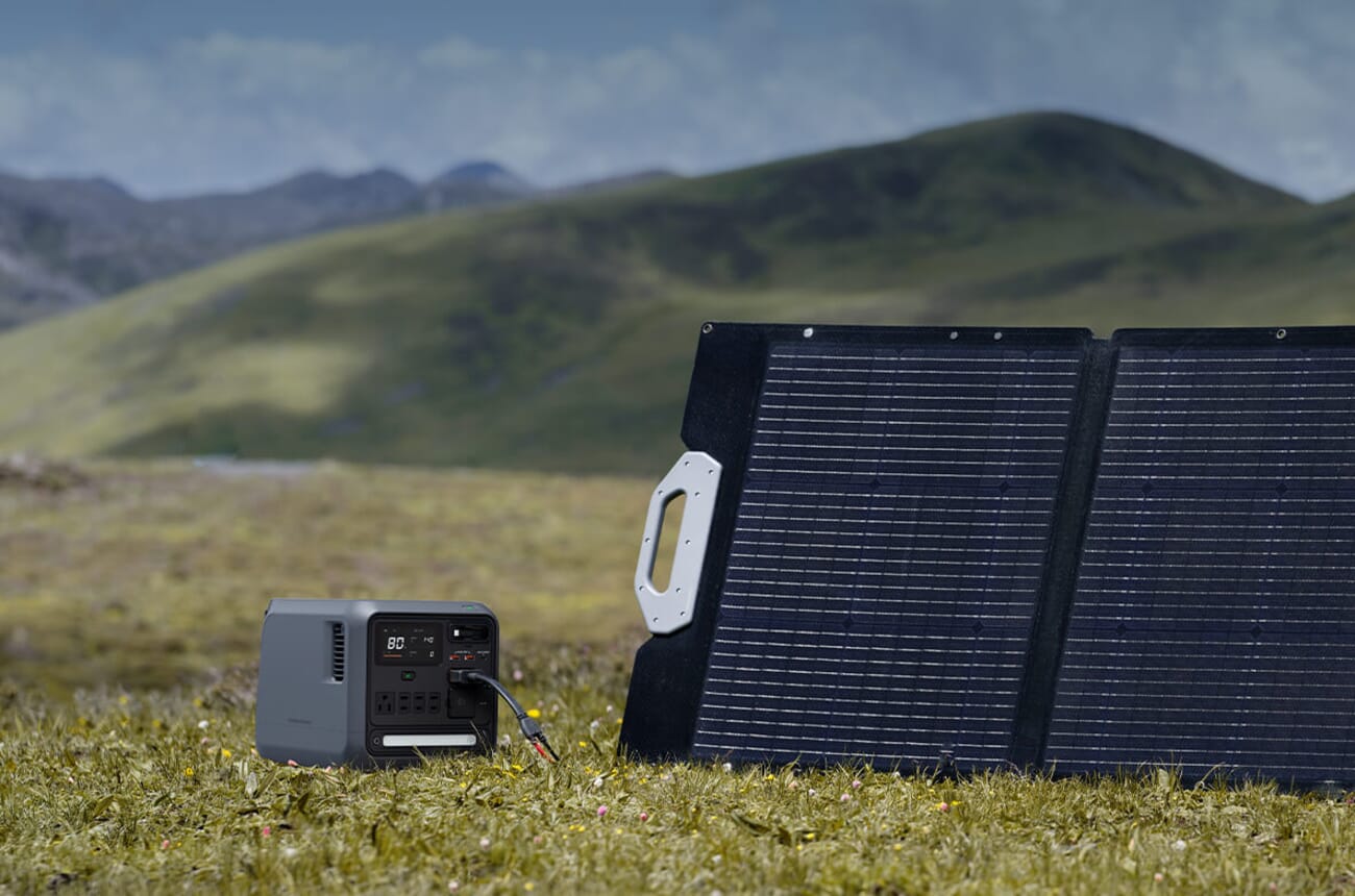 DJI Power 1000 Mini connected to a solar panel in a mountain field — solar input extends runtime on long shoots