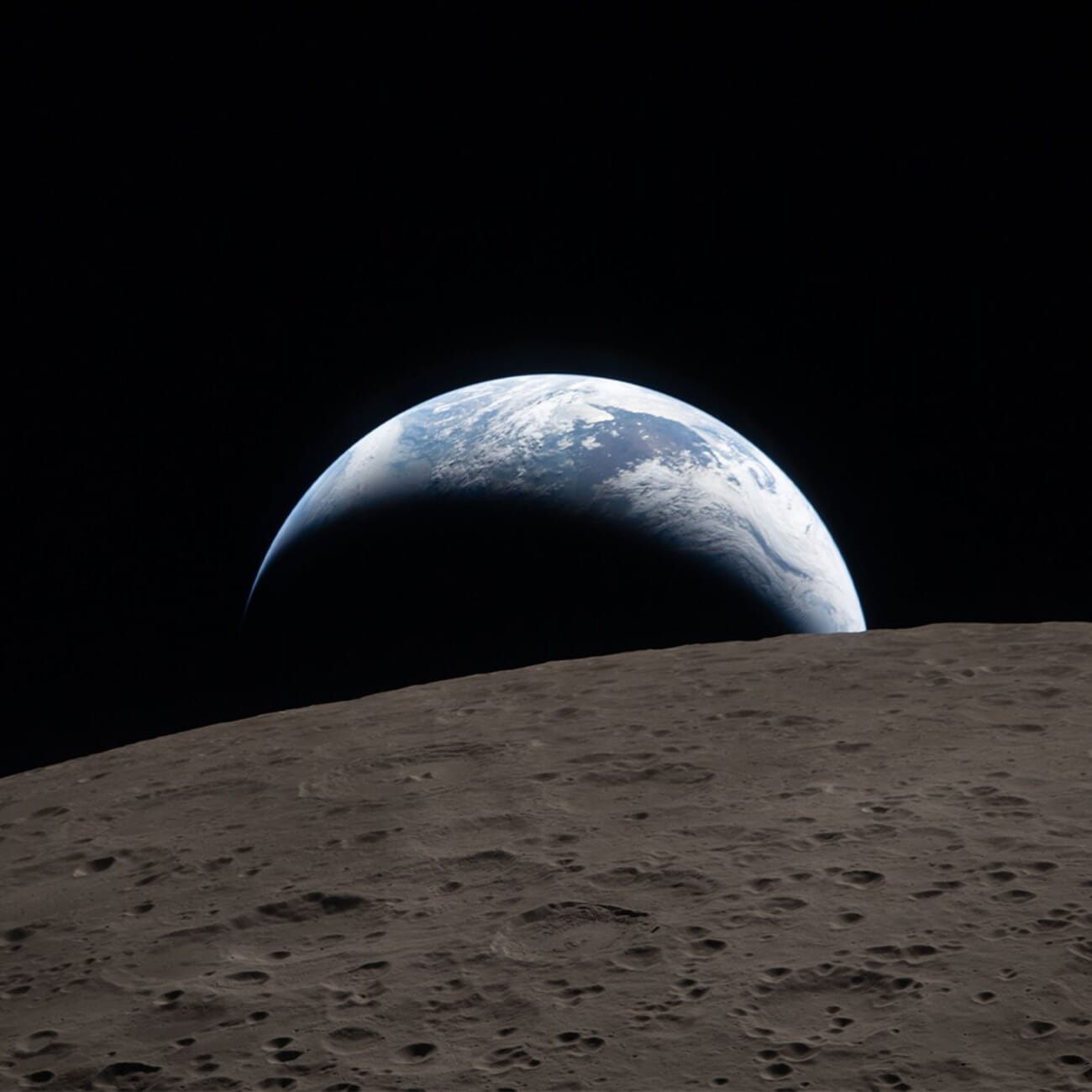 Crescent Earth rising over the lunar limb captured during the Artemis II flyby