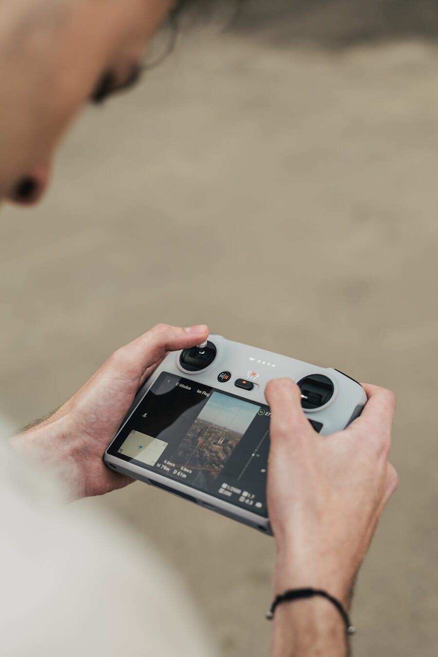 A drone pilot operating a quadcopter with a handheld controller