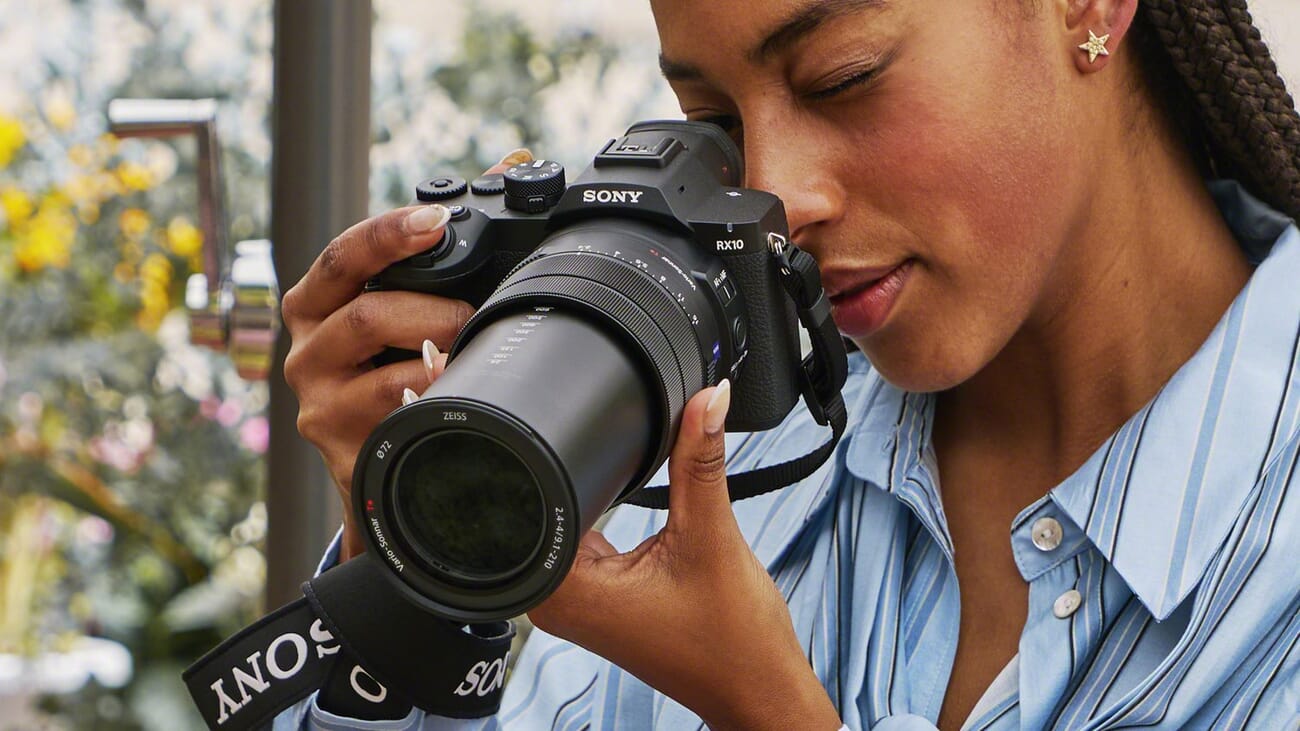 Angled view of the Sony RX10 V bridge camera showing the redesigned body, top dials, and Zeiss lens branding