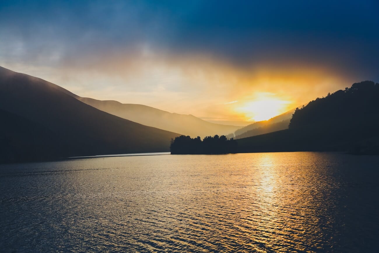 Golden sunset over a serene lake with mountain silhouettes captured on the Canon EOS RP at 53mm