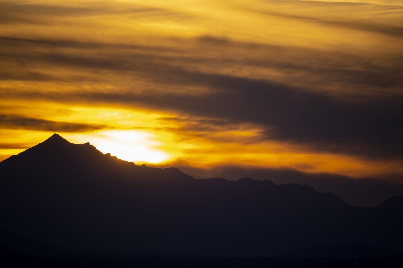 Dramatic golden sunset over layered mountain silhouettes captured on the Nikon Z50 at 250mm, 1/320s