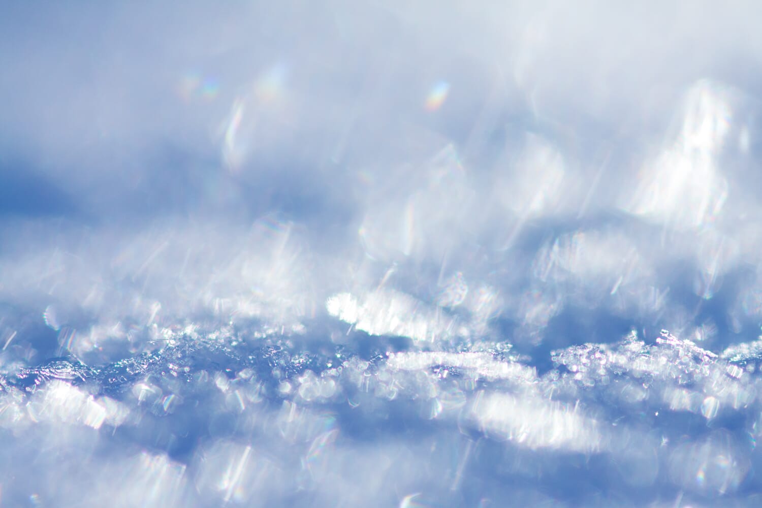 Close-up of blue ice with sparkling background bokeh.