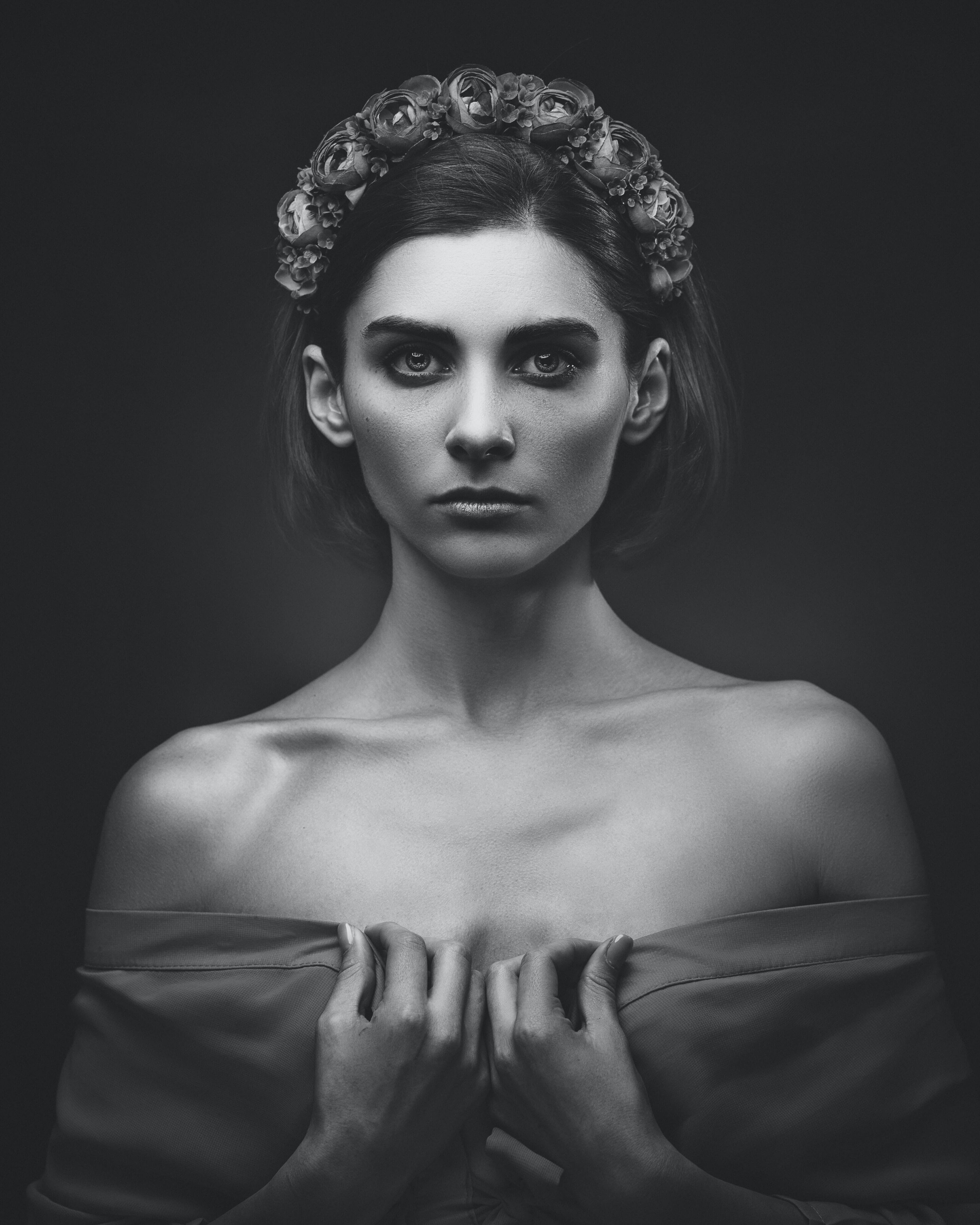 Stunning black-and-white portrait of a model with a floral headband, showcasing dramatic lighting. The detailed expression and soft shadows highlight the elegance of external flash.