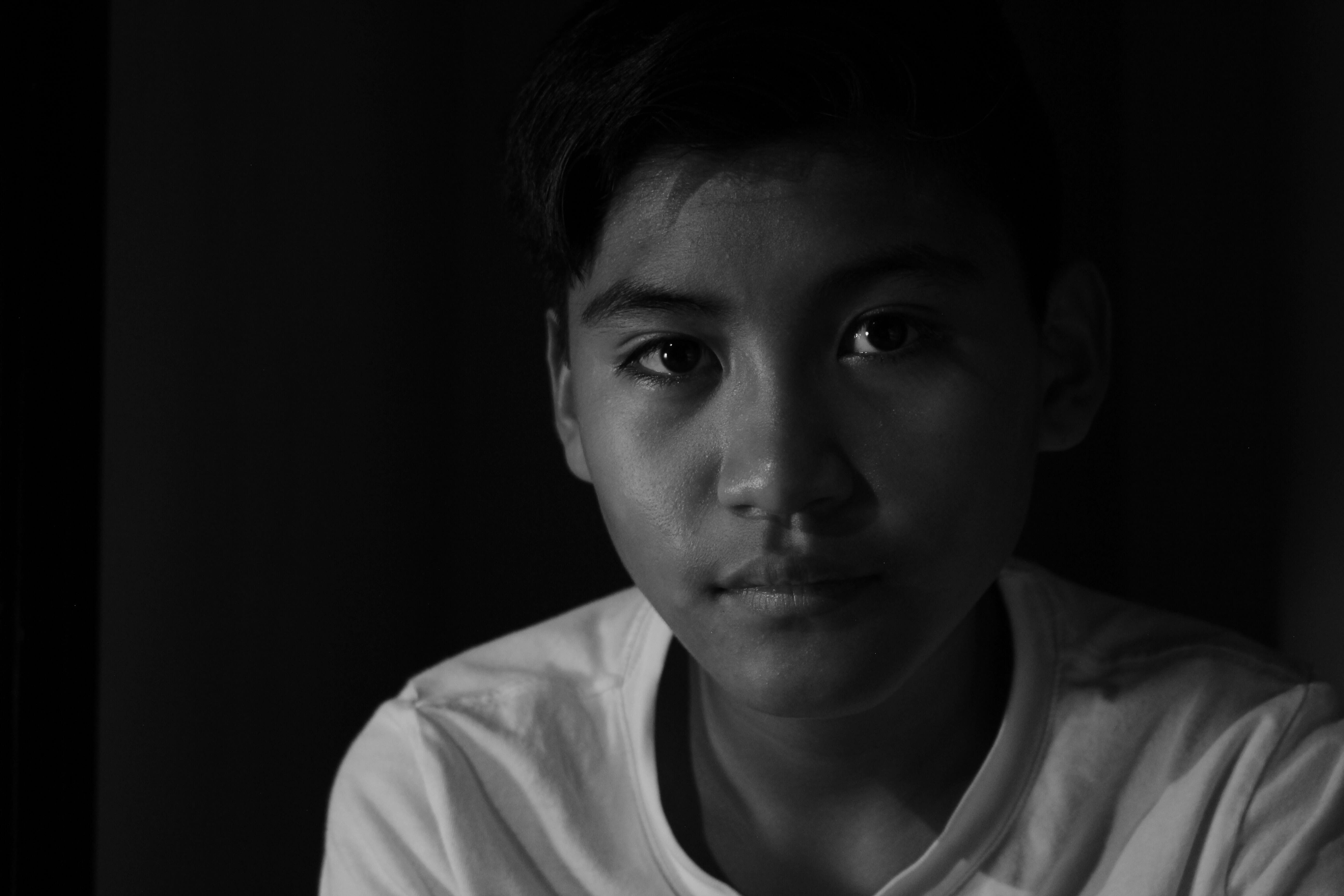 A striking black-and-white portrait of a young boy, showcasing dramatic shadows and highlights that emphasize his expressive eyes and facial features. Perfect for discussions on lighting.