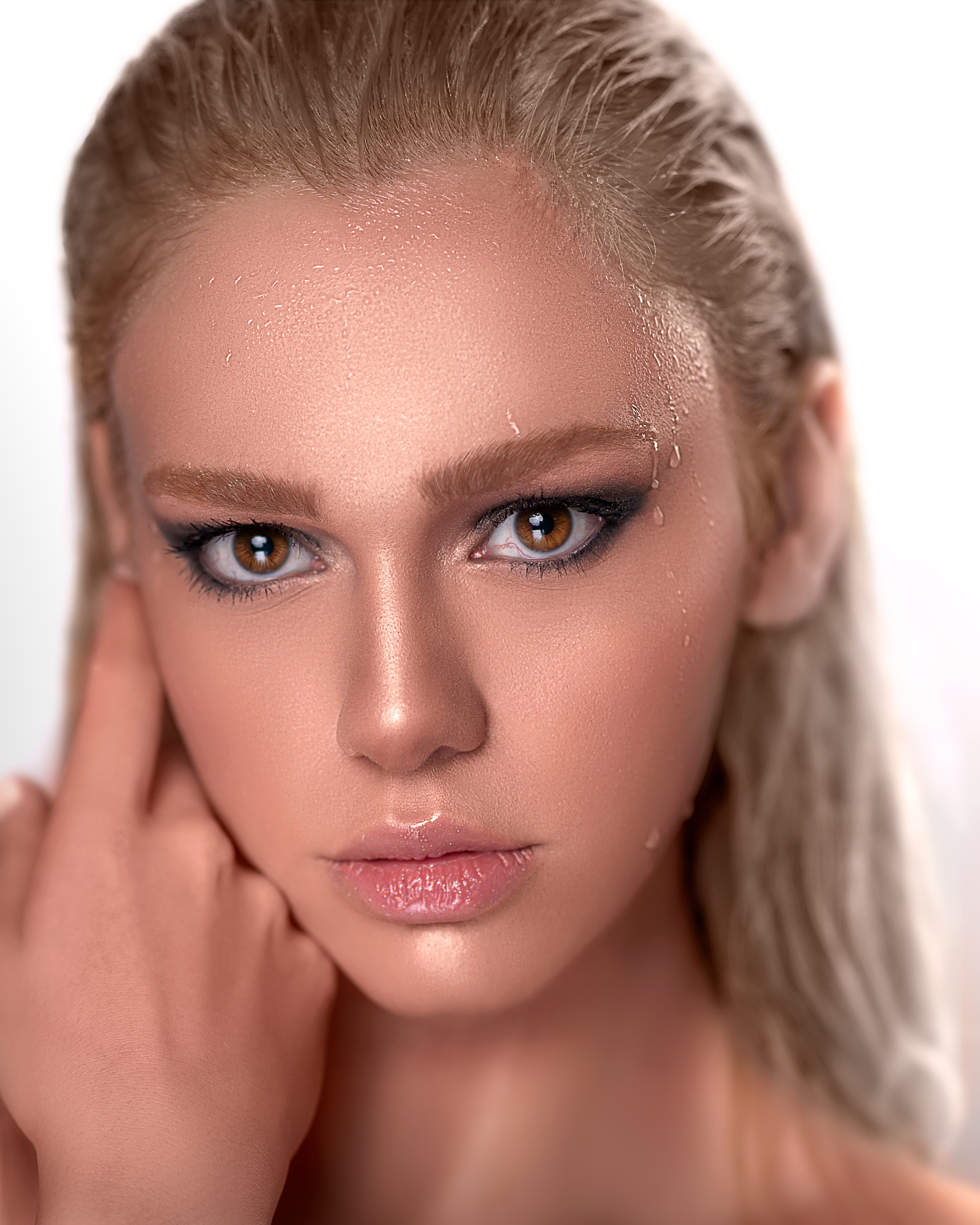 A stunning close-up portrait highlights a model with radiant skin, droplets of water, and captivating brown eyes. Ideal for illustrating the effects of external flash in.